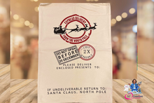 Load image into Gallery viewer, A beige personalized Santa sack with black and red text, a white reindeer silhouette, and the name &#39;Dillon&#39;. The sack is displayed against a blurred holiday-themed backdrop.
